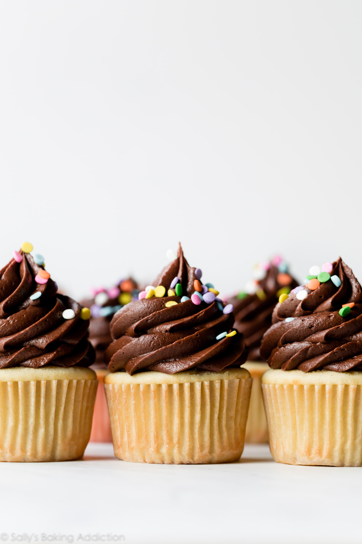 Cupcakes d'anniversaire jaunes avec glaçage au chocolat et paillettes