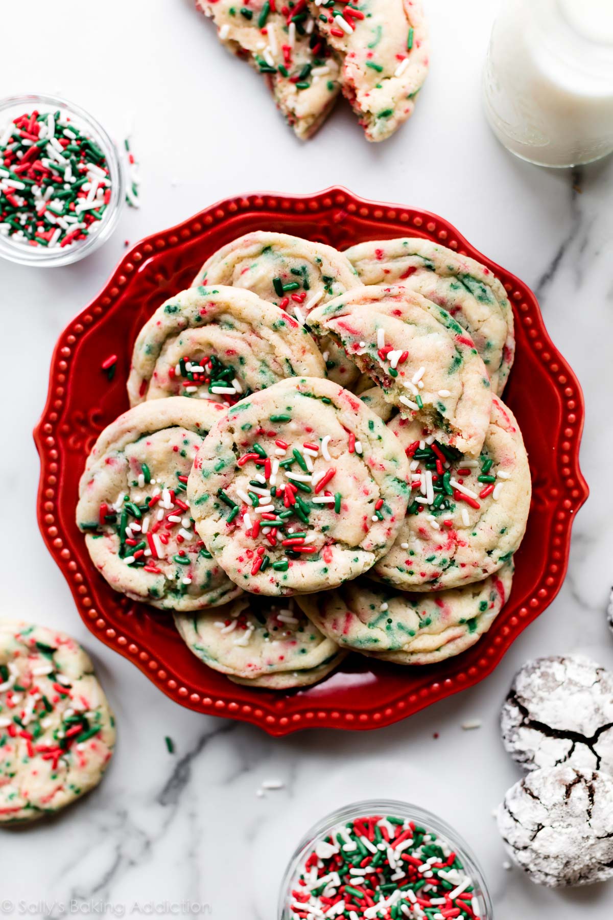 Biscuits de confettis de Noël doux et moelleux avec des paillettes rouges et vertes! Recette facile de biscuits au sucre sur sallysbakingaddiction.com