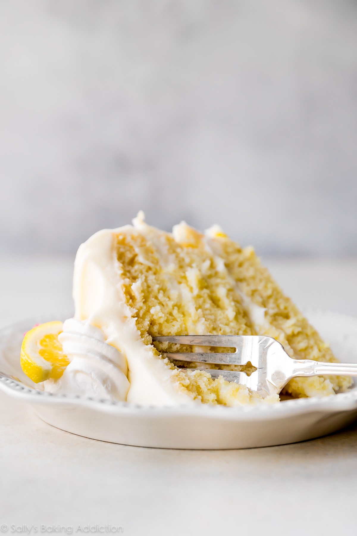 Gâteau moelleux au citron avec glaçage à la crème au beurre et au fromage à la crème au citron! Délicieuse recette de gâteau au citron fait maison sur sallysbakingaddiction.com