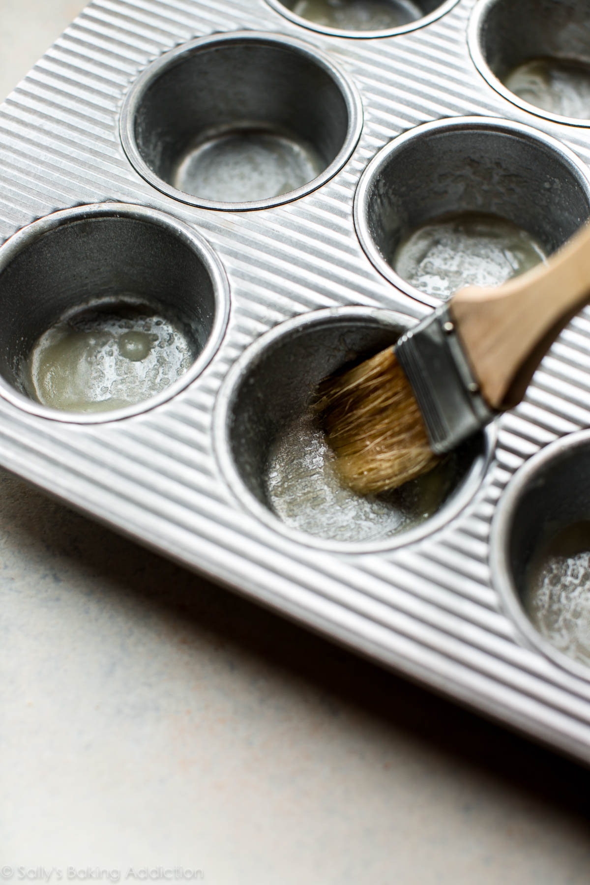 Brosser la poêle avec du beurre fondu et du sucre pour des gâteaux au thé aux graines de pavot et aux amandes sur sallysbakingaddiction.com