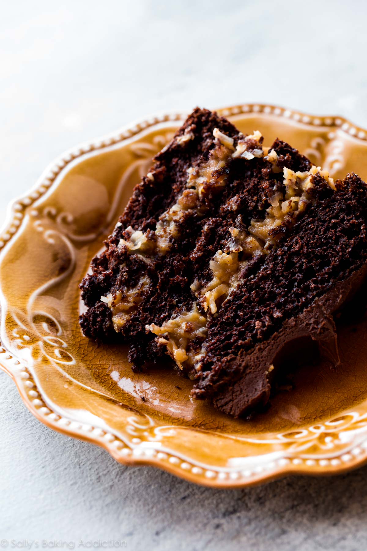 Gâteau au chocolat allemand moelleux et décadent avec un gâteau au chocolat fait maison, une garniture aux pacanes grillées et à la noix de coco et un glaçage au chocolat sur le dessus! Recette sur sallysbakingaddiction.com