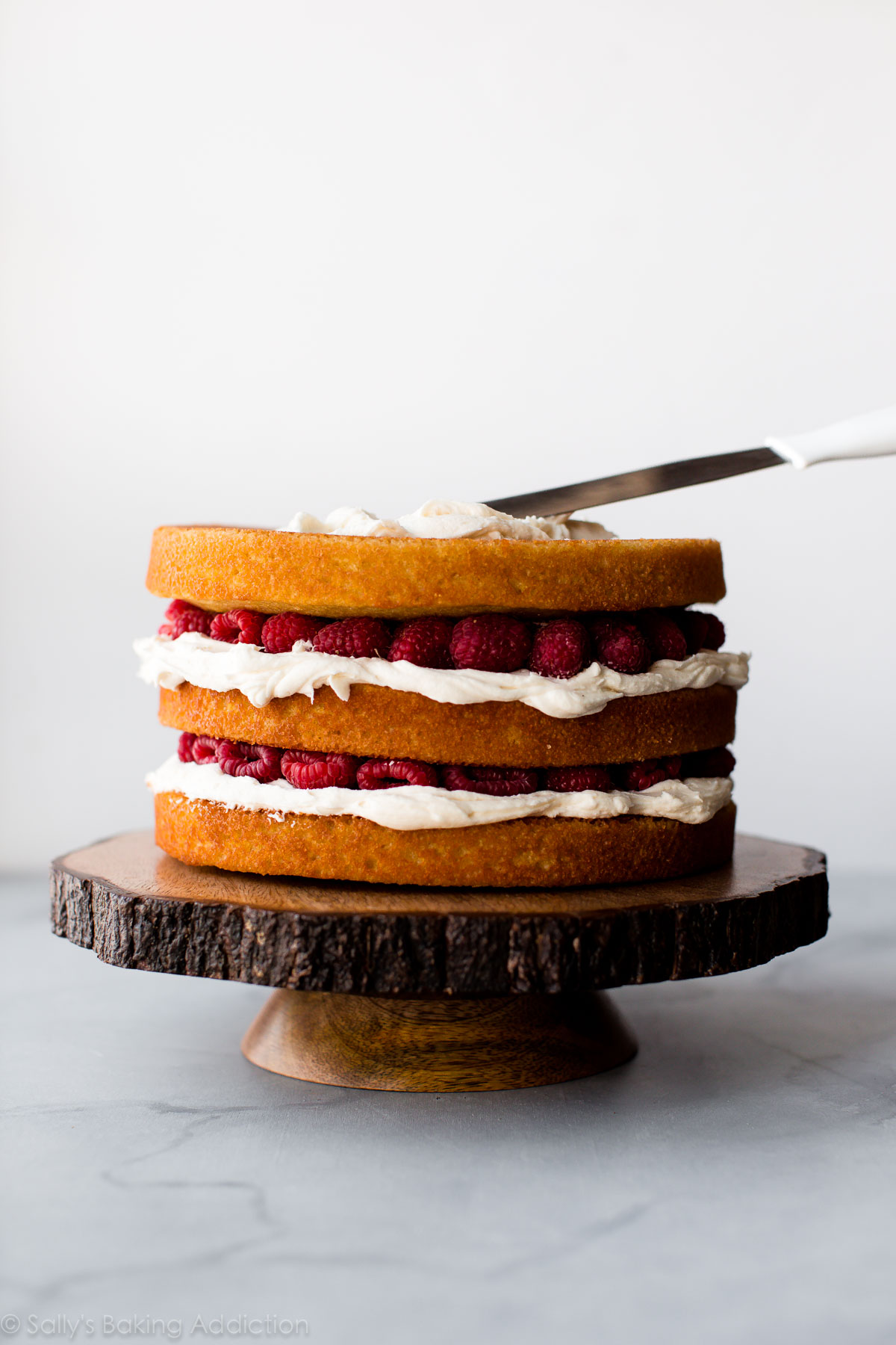 Comment faire un beau gâteau nu avec des baies fraîches, un gâteau à la vanille et une crème au beurre à la vanille. Gâteau de mariage fait maison sur sallysbakingaddiction.com