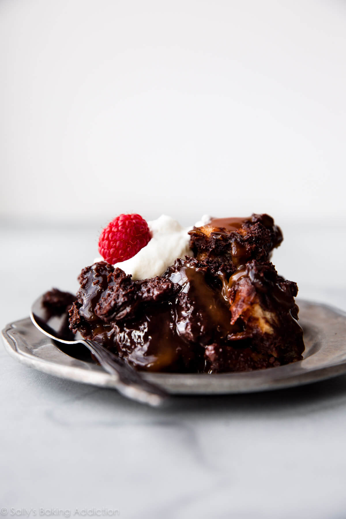 Ce pudding au pain au chocolat noir a le goût d'une poêle de brownies chauds et fondants. Pour le meilleur goût et la meilleure texture, utilisez du pain challah et du vrai chocolat. Recette sur sallysbakingaddiction.com