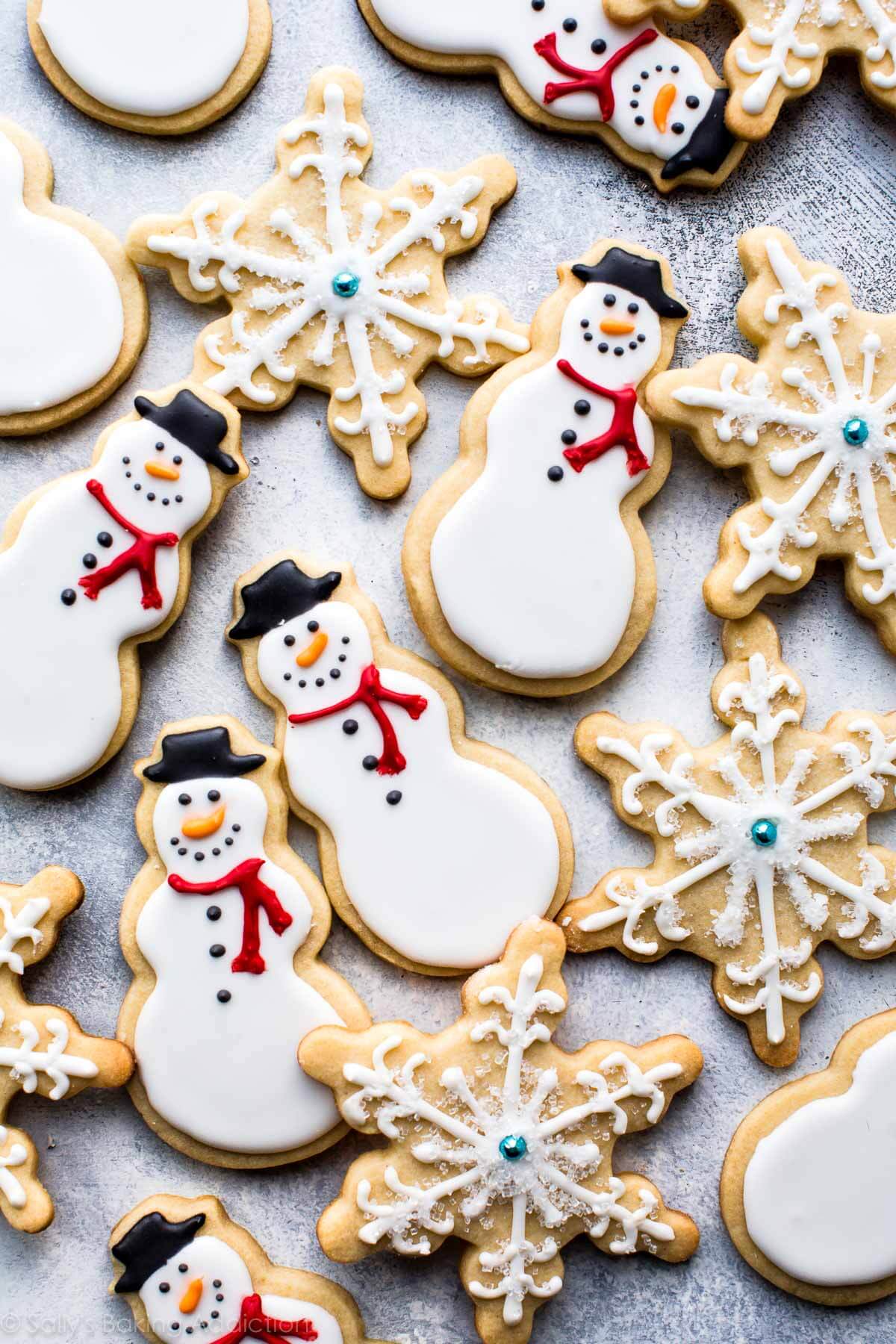 Apprenez à faire d'adorables biscuits au sucre bonhomme de neige et flocons de neige avec du glaçage royal! Recette de biscuits de Noël sur sallysbakingaddiction.com