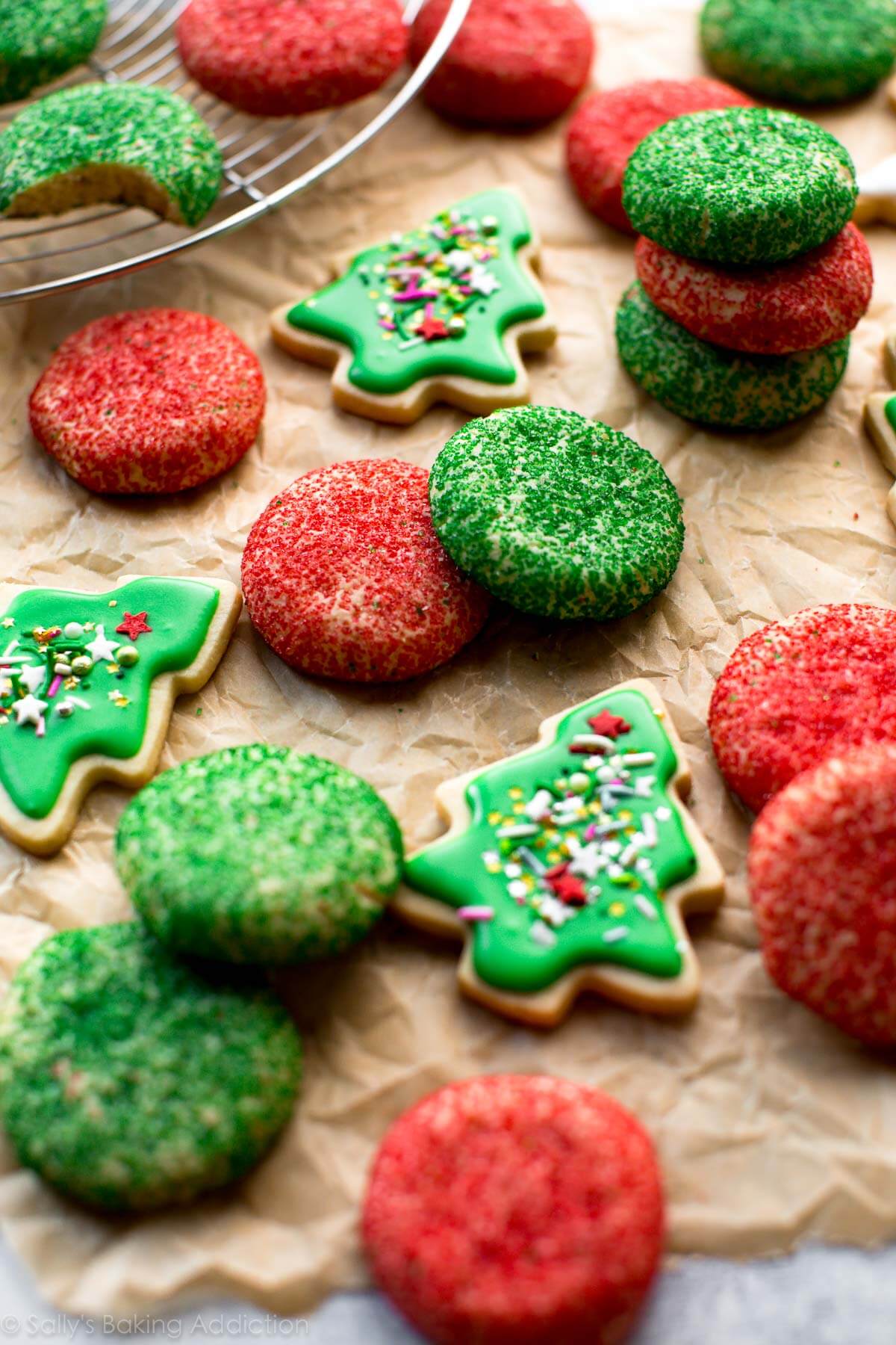 Biscuits au sucre à la crème vert et rouge mousseux avec la texture la plus douce et la plus crémeuse! Ces biscuits de Noël sont rapides et faciles aussi! Recette sur sallysbakingaddiction.com