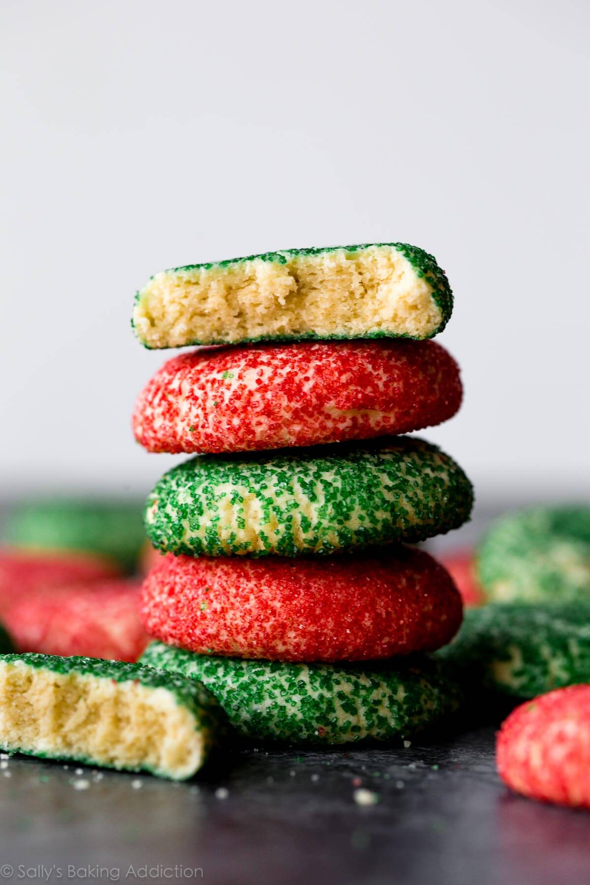 Biscuits au sucre à la crème vert et rouge mousseux avec la texture la plus douce et la plus crémeuse! Ces biscuits de Noël sont rapides et faciles aussi! Recette sur sallysbakingaddiction.com