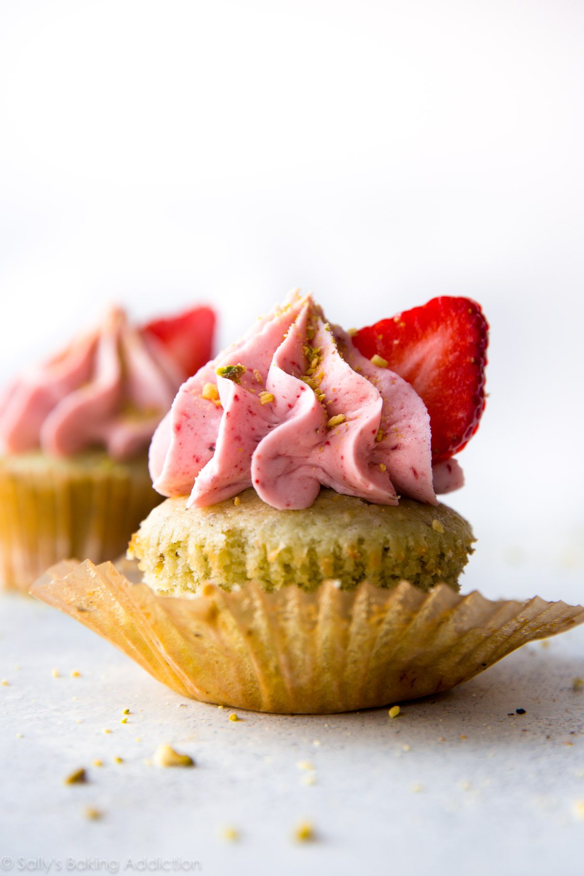 Cupcakes à la pistache délicieusement simples à partir de zéro avec un glaçage crémeux aux fraises! Recette sur sallysbakingaddiction.com