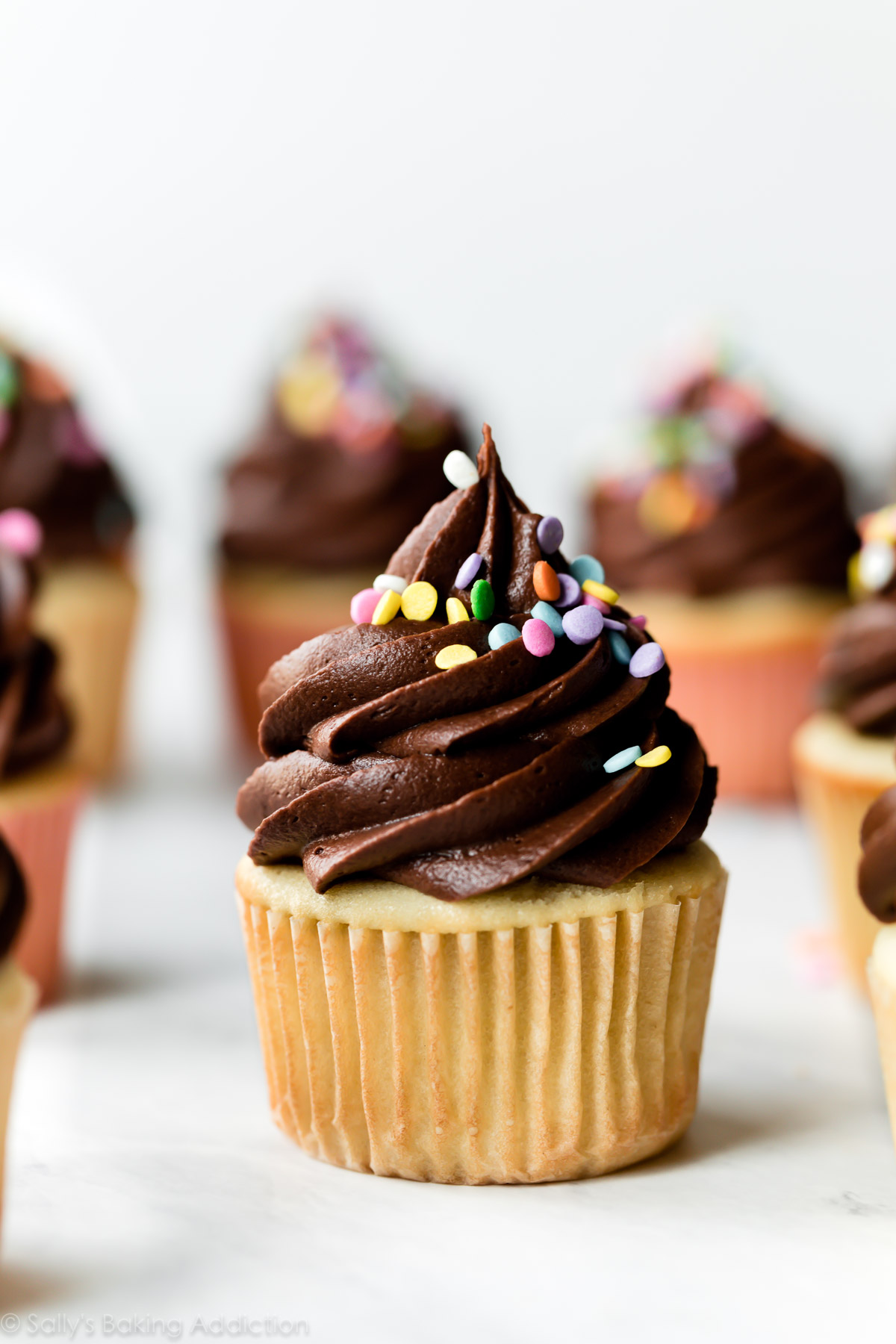 Cupcakes d'anniversaire jaunes avec glaçage au chocolat et paillettes