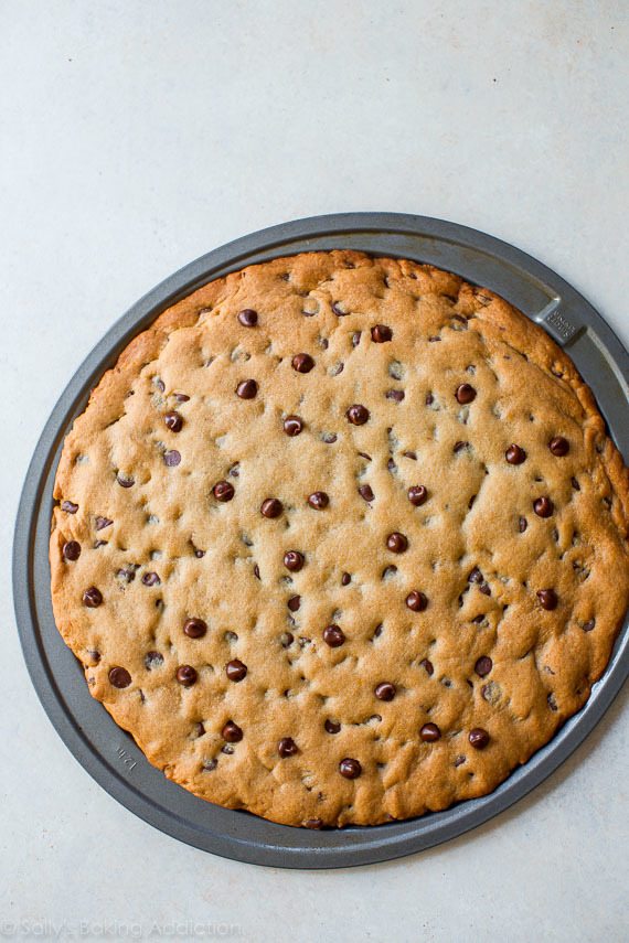 Cette recette facile pour une pizza aux cookies aux pépites de chocolat classique! Rend une pizza cookie géante parfaite pour le partage. Recette sur sallysbakingaddiction.com