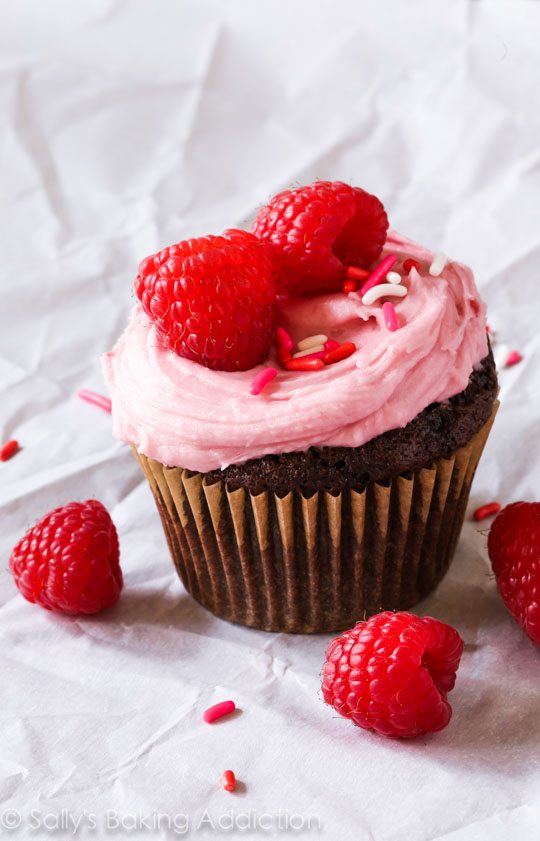 Les MEILLEURS petits gâteaux au chocolat maison givrés avec un glaçage crémeux aux framboises fait avec des conserves de framboises. Recette sur sallysbakingaddiction.com