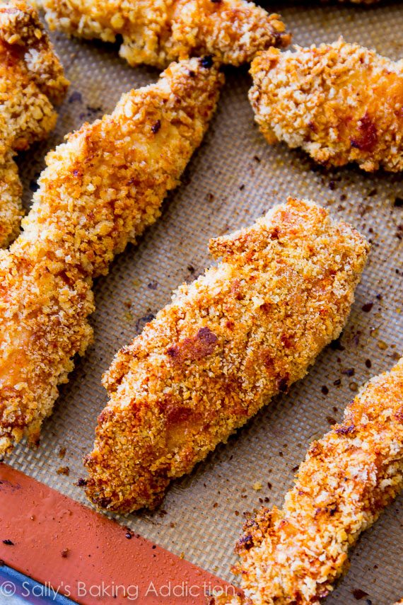 Ces doigts de poulet extra croustillants marinés dans du miel et de la sauce barbecue. Au four, pas frit! Recette facile sur sallysbakingaddiction.com
