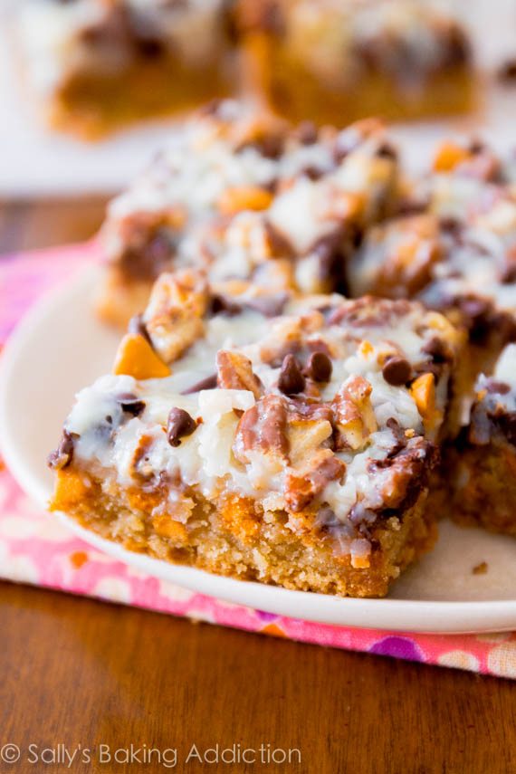 Ultimate Magic Cookie Bars avec du caramel au beurre, du chocolat et de la noix de coco! Obtenez la recette sur sallysbakingaddiction.com