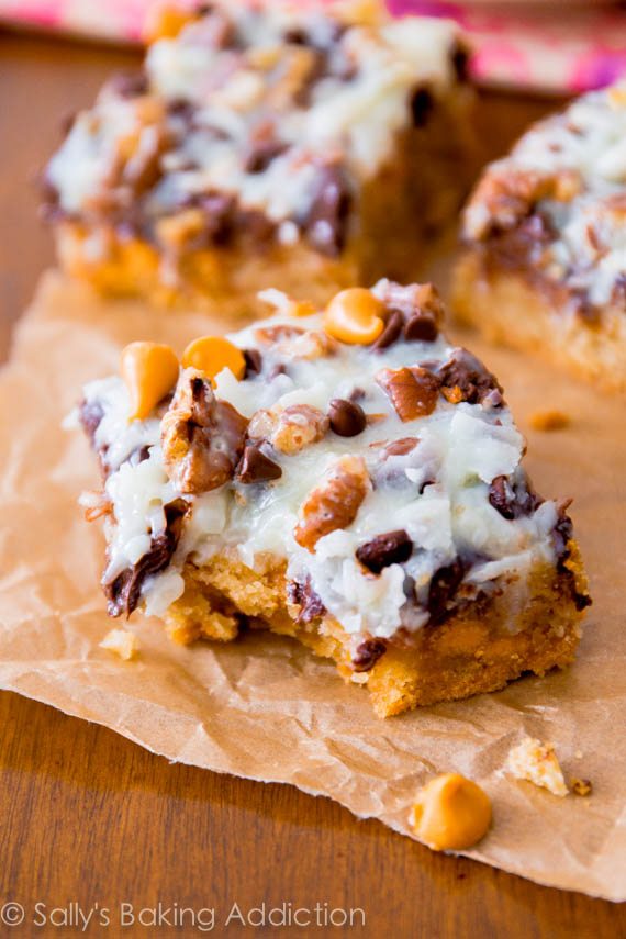 Ultimate Magic Cookie Bars avec du caramel au beurre, du chocolat et de la noix de coco! Obtenez la recette sur sallysbakingaddiction.com