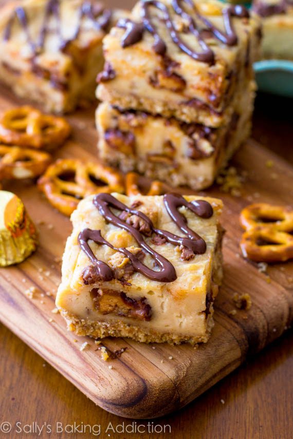 Barres de gâteau au fromage au beurre d’arachide en croûte bretzel. Croûte salée et croquante avec un gâteau au fromage au beurre d’arachide décadent et crémeux. Garni d’une bruine de chocolat décadente! sallysbakingaddiction.com