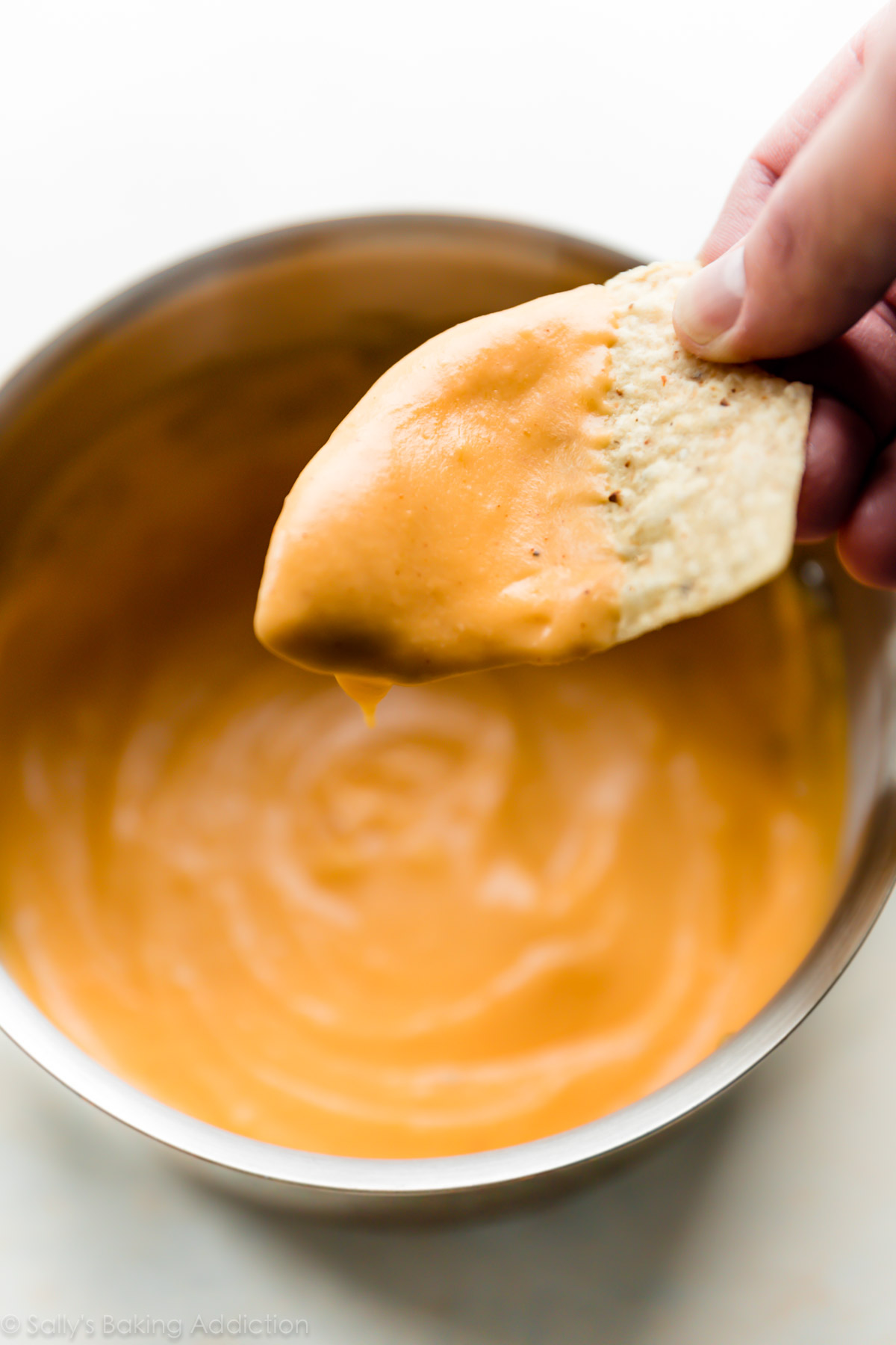 La sauce au nacho épicée maison la plus incroyable! Sauce crémeuse au fromage pour des collations, des bretzels mous, du pain et plus encore! Recette sur sallysbakingaddiction.com