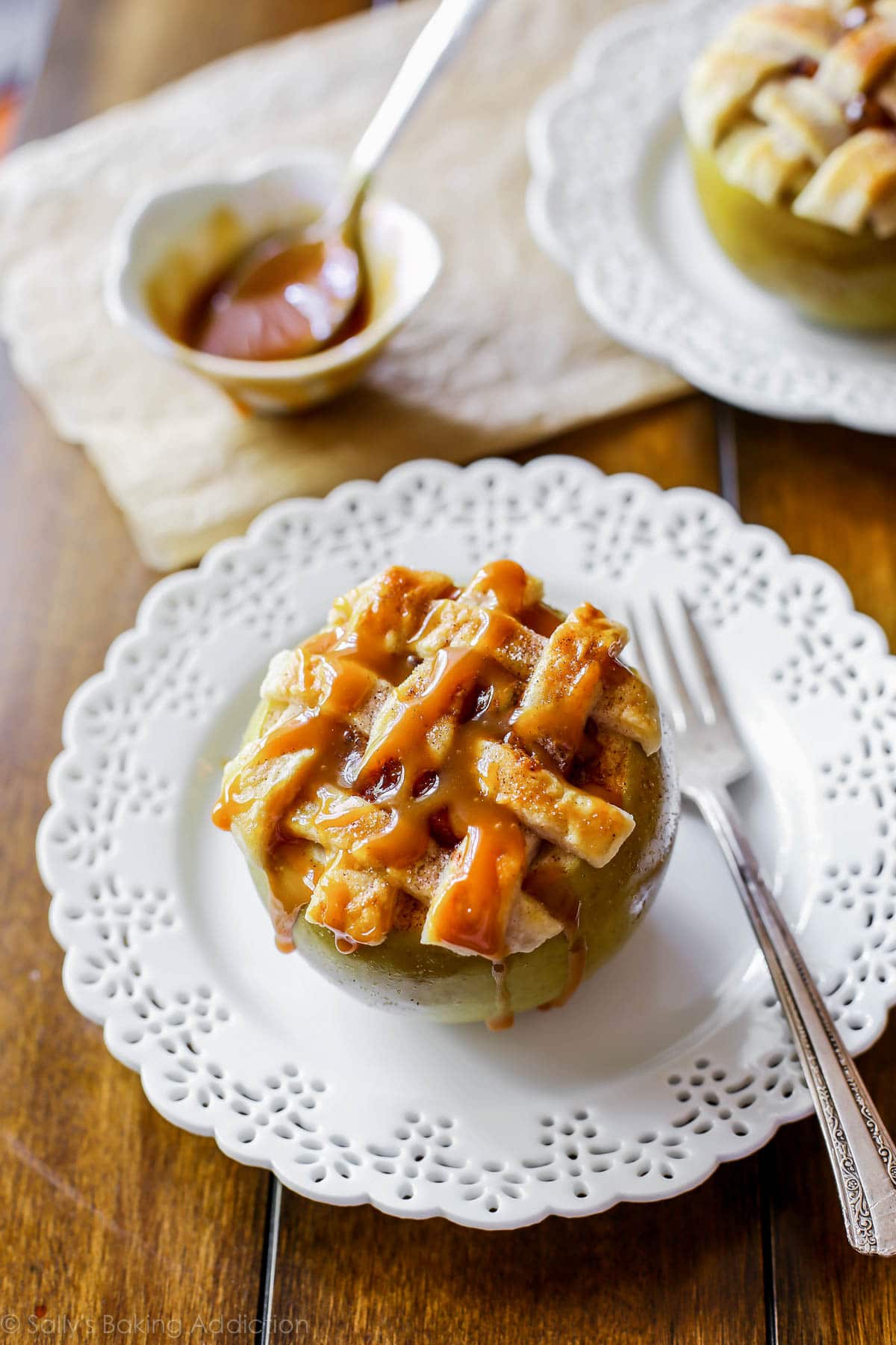 Tarte aux pommes cuite dans une pomme! Garni de croûte de tarte au beurre et de sauce au caramel salé. Recette facile de tarte aux pommes sur sallysbakingaddiction.com