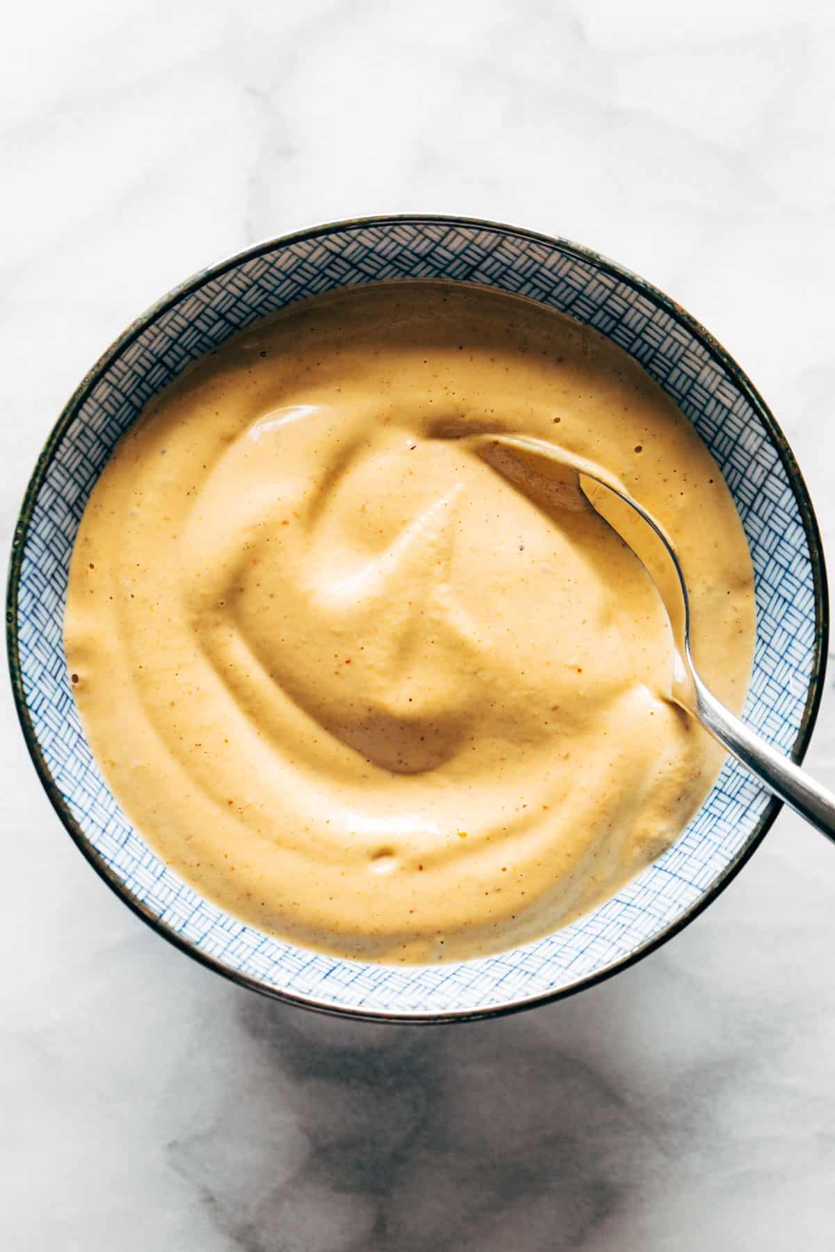Chipotle noix de cajou queso dans un bol avec une cuillère.
