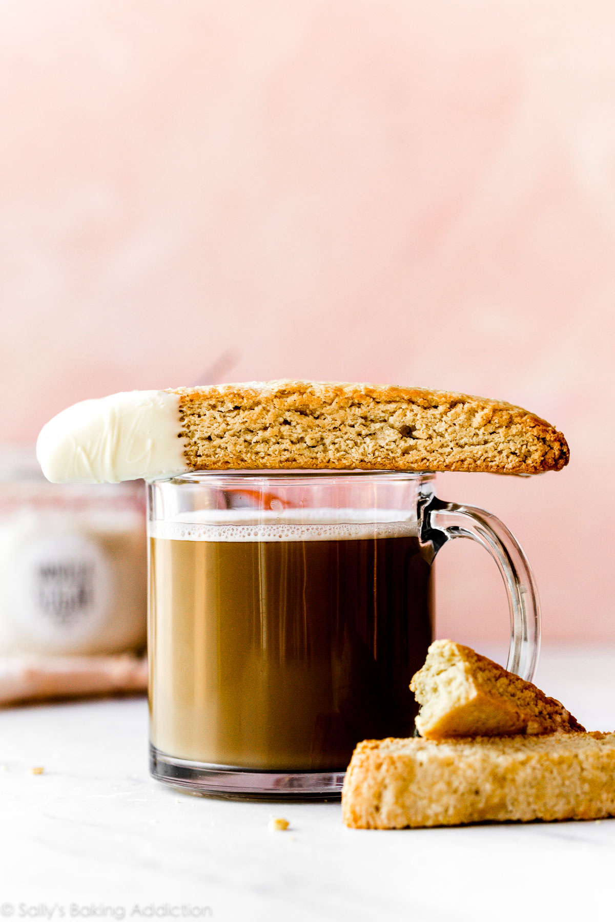 Biscotti à la vanille trempé dans du chocolat blanc assis sur une tasse de café