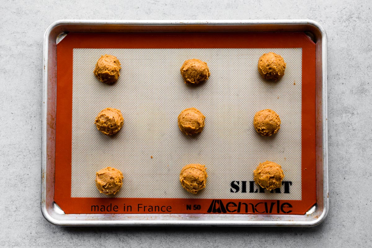 Boules de pâte à biscuits à la citrouille sur une plaque à pâtisserie