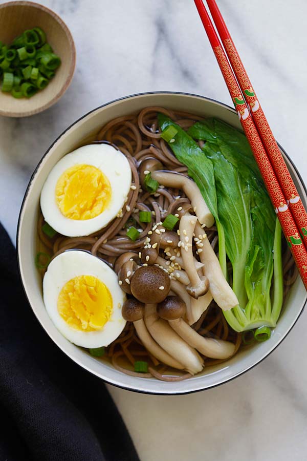 Soupe de nouilles soba japonaises rapide et facile avec des œufs durs et des légumes verts asiatiques dans un bol.