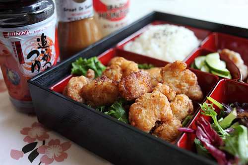 Karaage de poulet japonais fait maison facile servi dans une boîte à lunch bento avec des accompagnements, prêt à servir.