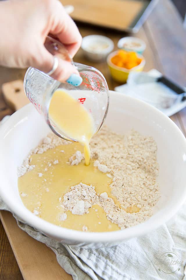 Le mélange d'oeufs et de lait est versé dans une tasse à mesurer en verre et dans un bol blanc contenant de la farine et de l'avoine