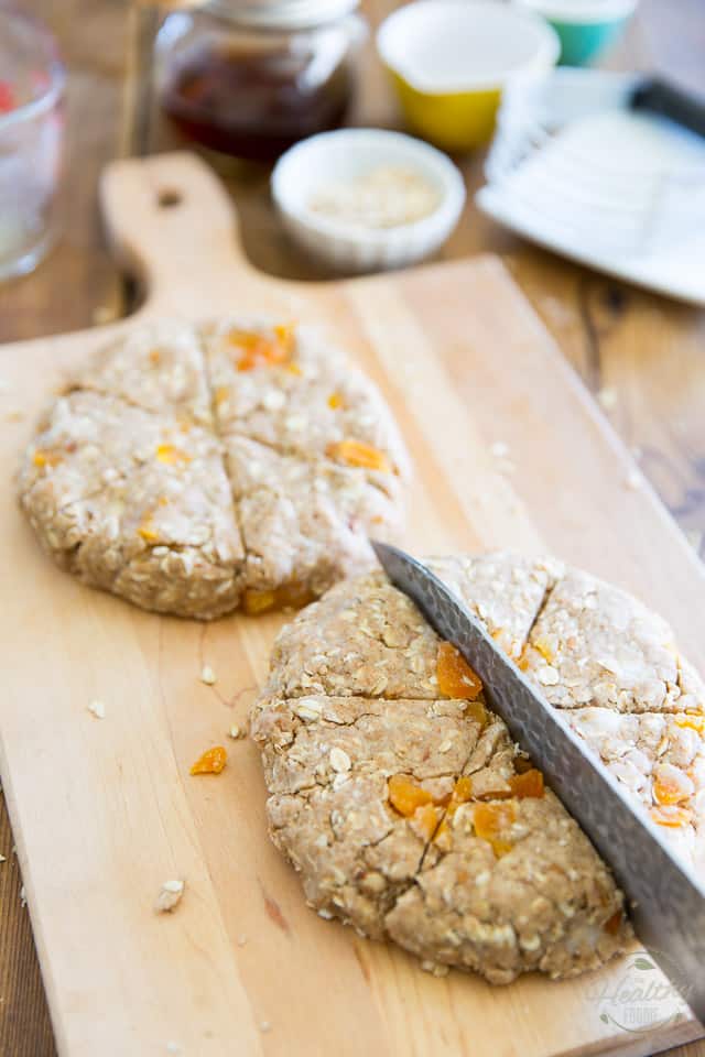 Pâte à scone en forme de disques sur une surface de travail en bois, se fendant au couteau