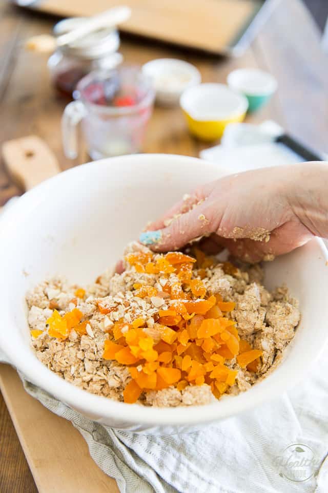 Des abricots et des amandes hachés sont ajoutés à la pâte à scones et mélangés d'une seule main