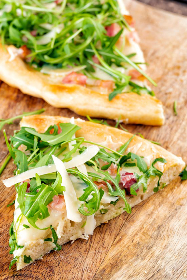 2 tranches de pizza blanche sur une planche de bois.