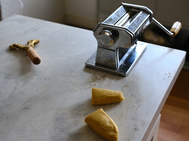 Pâte à pappardelle à côté d'une machine Atlas Pasta