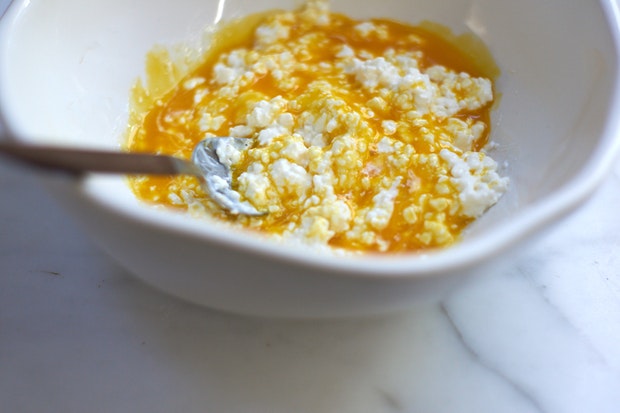jaunes d'oeufs et fromage cottage dans un bol à mélanger blanc
