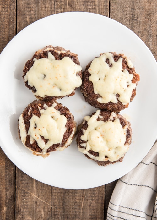 Les hamburgers faits sur une assiette blanche.