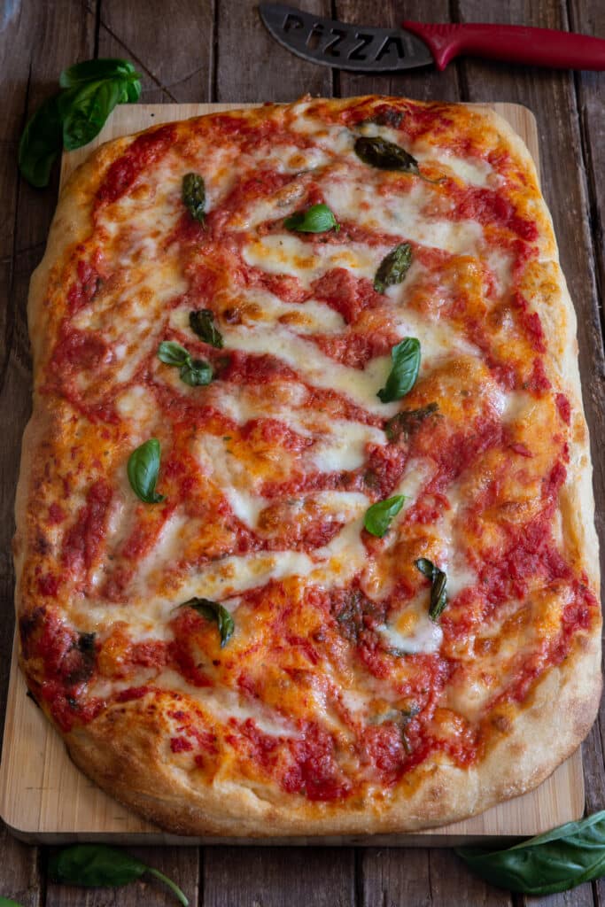Pizza Margherita sur une planche de bois.
