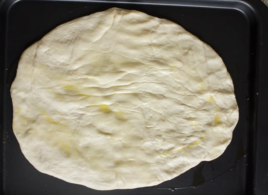 Pâte à pizza sur une plaque à pâtisserie.